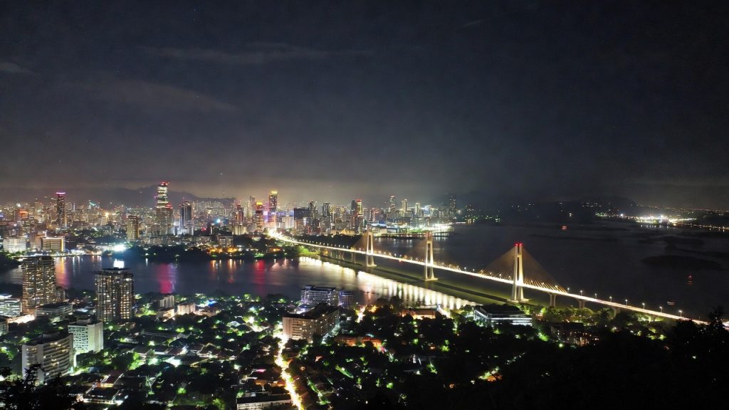 Pemandangan gedung pencakar langit Surabaya dan Jembatan Suramadu saat malam hari